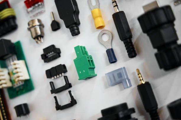 Composition with set of different types plugs and connectors of electric equipment on white surface close view from above